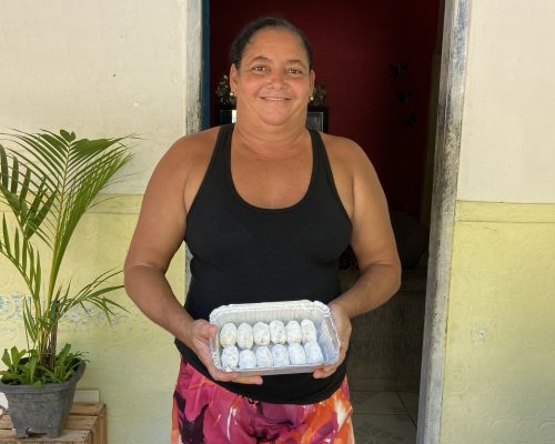 Moradora da comunidade com bolinhos de peixe_Crédito da imagem - Thaís Maciel